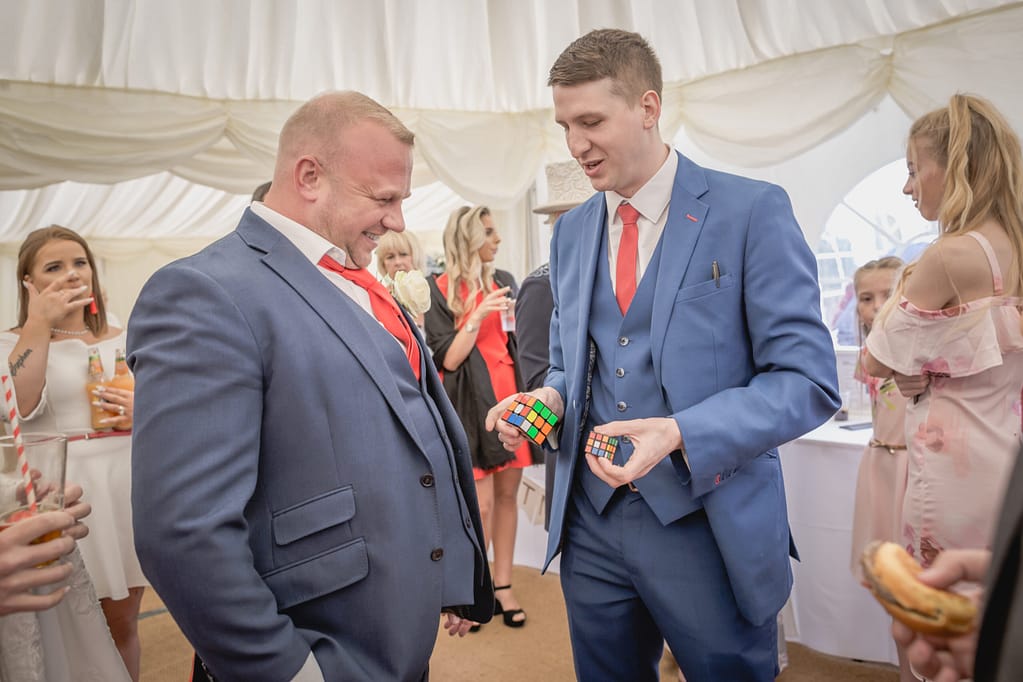 Wedding guests enjoying interactive close-up magic in London.