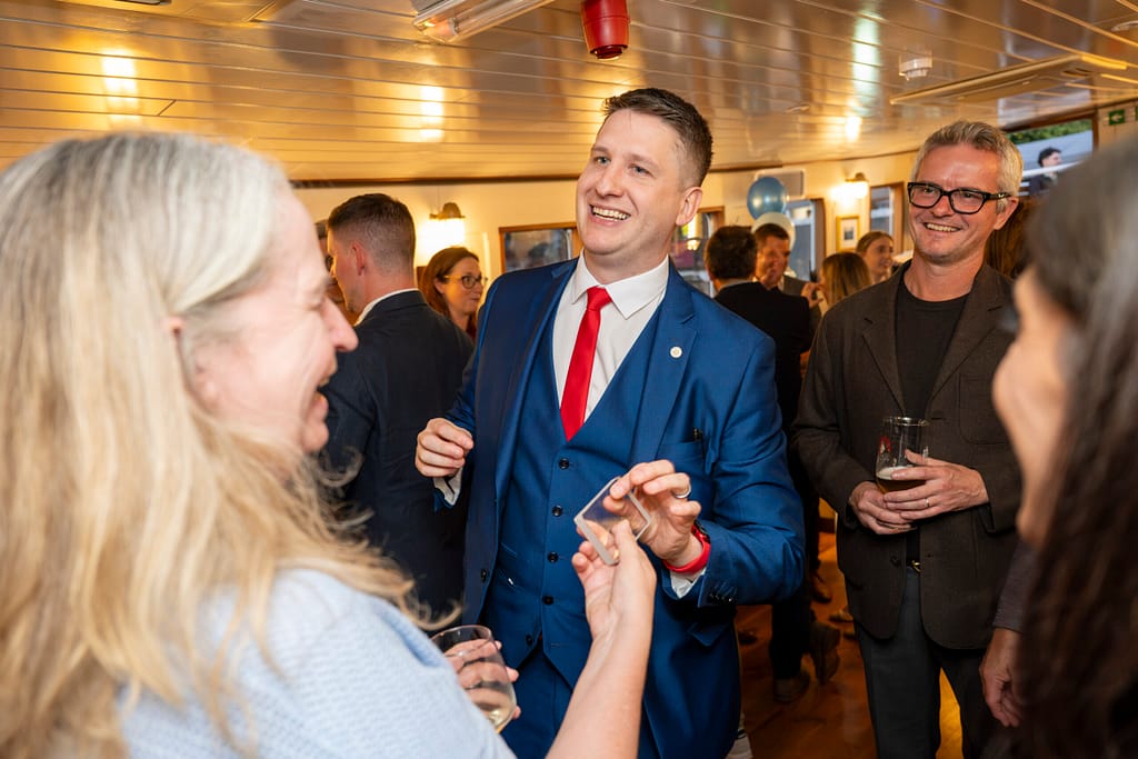 Magic Circle magician performing sleight of hand at an event in London, between courses at dinner.
