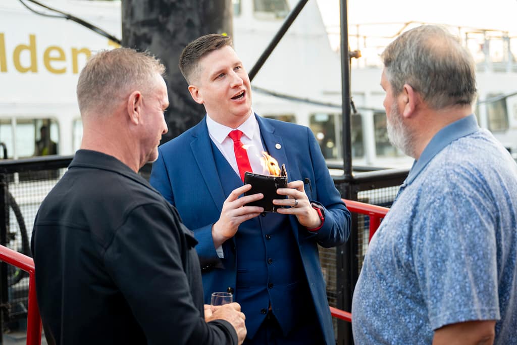 Close-up magician entertaining guests with card magic in London, between courses at dinner.