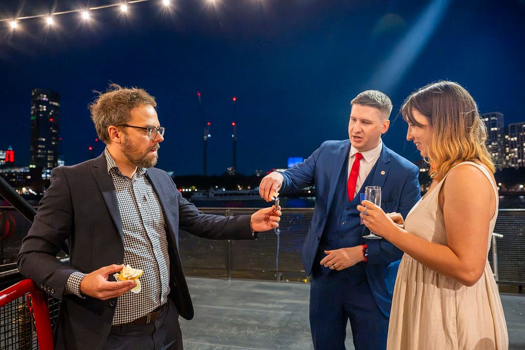 Magician Pete James performing close-up magic for guests in London, between courses at dinner.