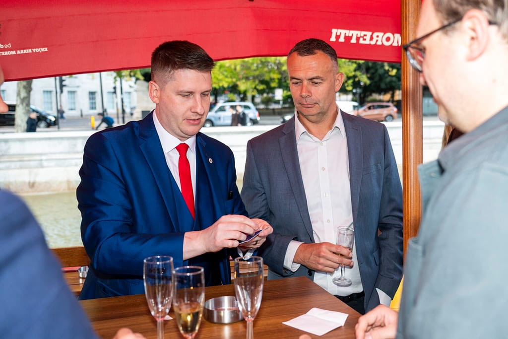 Professional magician performing mind-reading for a small group in London, during the drinks reception.